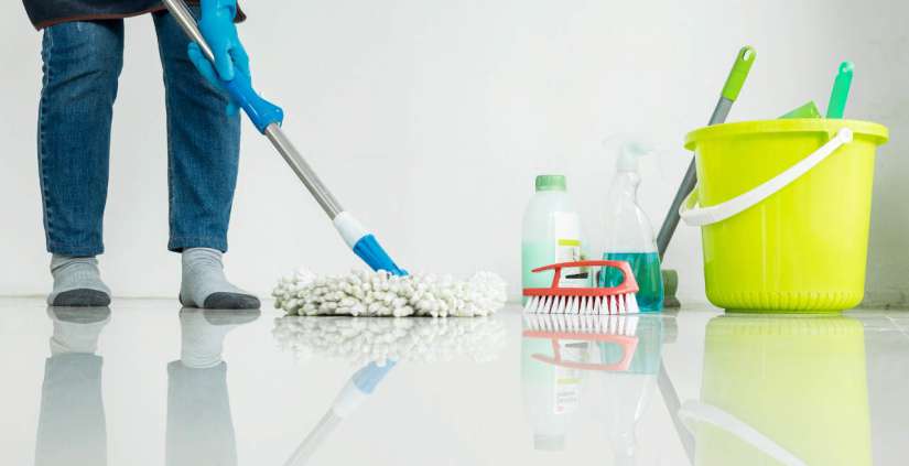 Eine Frau reinigt den Boden mit ein Mop.